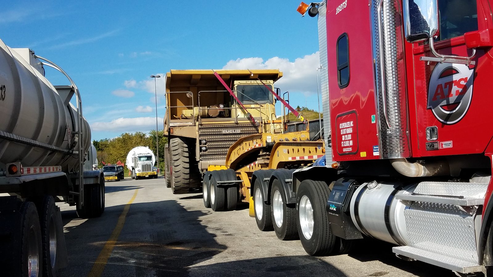 Euclid mining haul truck loaded for transport behind a heavy tractor